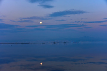 Thessalonian Bay of Mediterranean Sea at sunset (blue, purple) with a moon rising