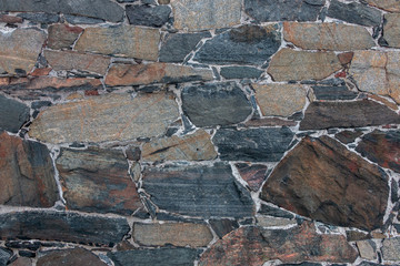 Stone wall texture. Masonry with natural cobblestones and granite slabs