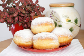 Sweet and tasty homemade traditional donuts on the plate on the kitchen table