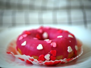 cake donut with white, pink and red hearts on a plate