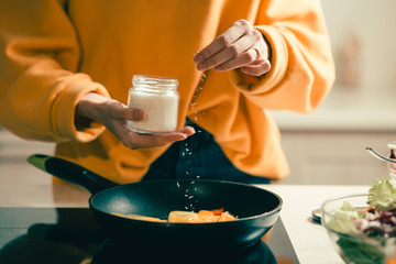 Close up of woman adding coconut flakes to the meal