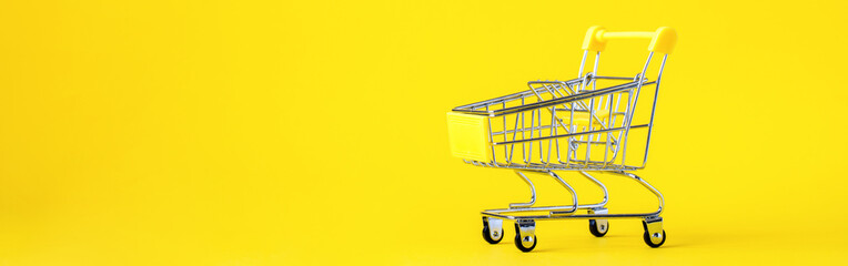 Shopping cart trolley basket is empty on a bright yellow background. Conception Festive Sale Discount. Trading Supermarket Retail.Copy space .Banner. © lily_rocha