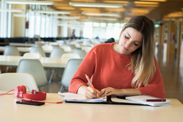 Young female student studying in the library.