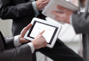 close up.businessmens discuss schedule of sales through the tablet