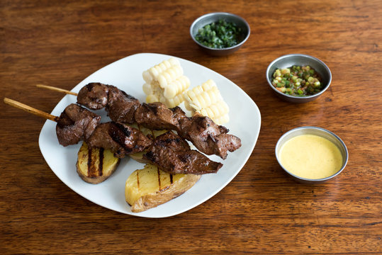 anticuchos, Peruvian cuisine, grilled skewered beef heart meat with boiled potato and white corn