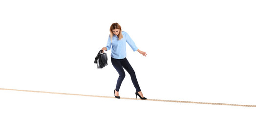 Full length portrait of businesswoman with briefcase balancing on rope against white background