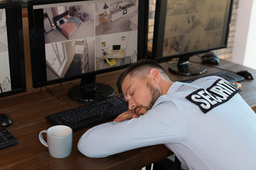 Male security guard sleeping at workplace. CCTV surveillance