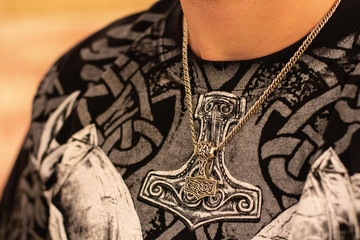 thor's hammer amulet on the neck