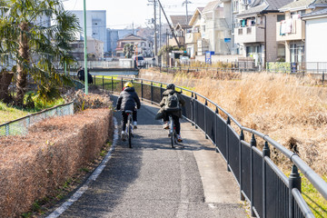 川沿いの道を自転車で通学