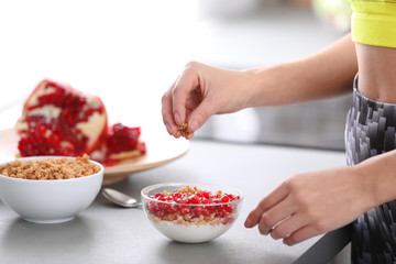 Young woman in fitness clothes preparing healthy breakfast at home, closeup