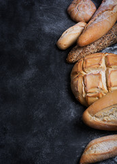 Fresh bread on a black chalkboard. Top view with copy space