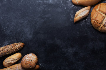 Fresh bread on a black chalkboard. Top view with copy space