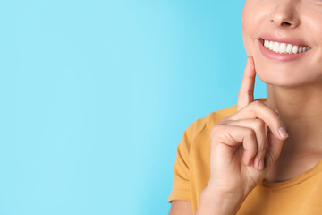 Young woman with healthy teeth on color background, closeup. Space for text