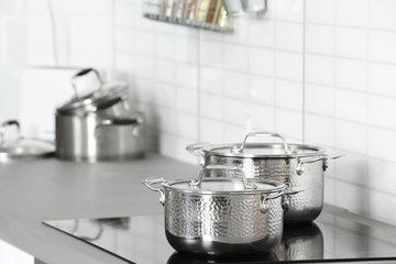 Clean pans on stove in kitchen. Space for text