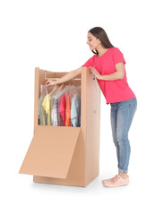 Young woman near wardrobe box on white background