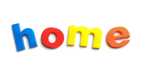 Word HOME of magnetic letters on white background, top view