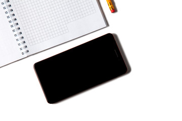 An open notebook, pencil and mobile phone on a white isolated background