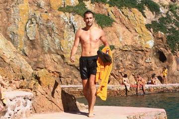 Sixpack Mann mit Handtuch in Badeshorts