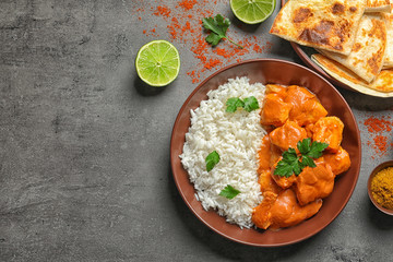 Butter chicken with rice served on grey table, flat lay. Space for text