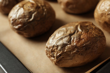Tray with baked jacket potatoes, closeup view