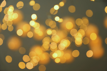 Blurred view of gold lights on dark background. Bokeh effect