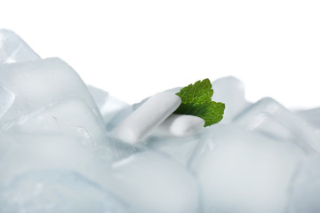 Chewing gums and mint on ice cubes against white background, closeup