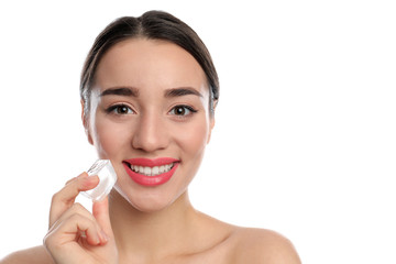 Young woman with ice cube on white background. Skin care