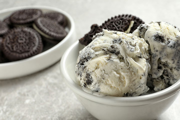 Bowl of chocolate cookies ice cream on table, closeup. Space for text