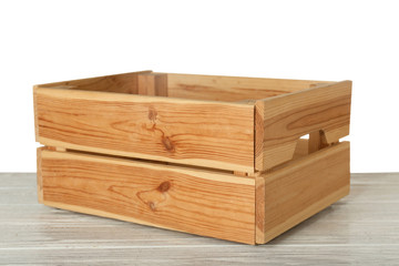 Empty rustic wooden crate on table against white background