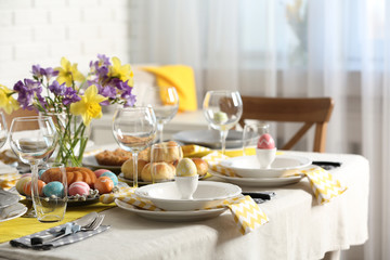Festive Easter table setting with traditional meal at home, space for text