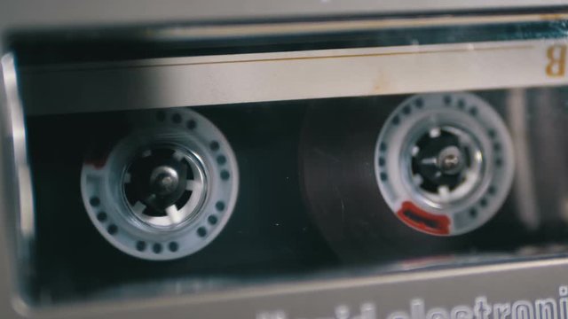 Audio Cassette is inserted into the Deck of the Audio Tape Recorder Playing and Rotates