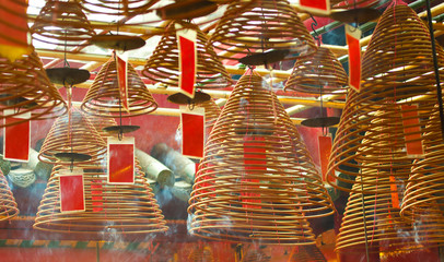 Fototapeta na wymiar Burning incense coils with red Prayer Flags. Man Mo Temple, Hong Kong. Landmark and a Popular tourist attractions