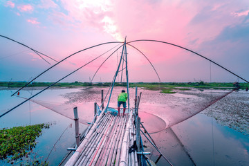  Fisherman catch it fish with traditional trap with sunset view.