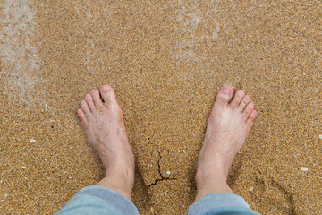 Relaxing at a beach, with your feet in the wet sand