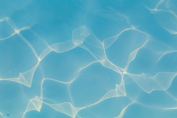 Blue pool water with sun reflections