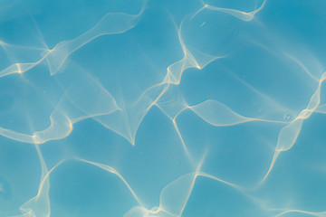 Blue pool water with sun reflections