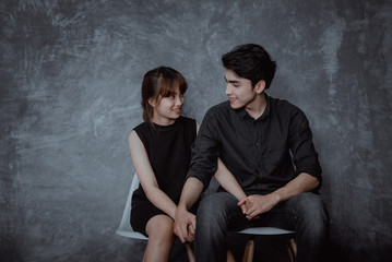 Young couple sitting chairs and holding hands than they have happiness in love and embrace with a sweet and romantic moments.