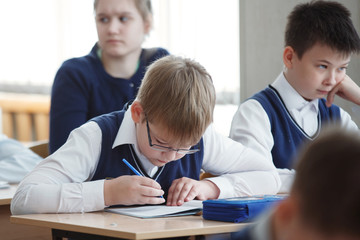 Obraz premium Schoolchildren sit at their desks in the classroom during school hours.