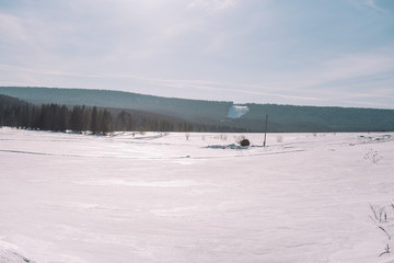 Village in the winter. Houses in Siberia under the snow. Buildings in the snow. Countryside in winter.