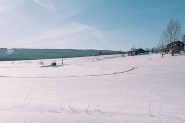 Village in the winter. Houses in Siberia under the snow. Buildings in the snow. Countryside in winter.