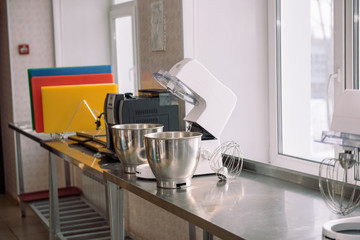 Mixer for whipping. Device for mixing products. Cook cakes. Metal mixer on the table. Learn to cook sweet cupcakes.