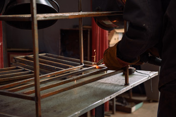 The welder makes the part. Worker welds the details. Master of semi-automatic welding.