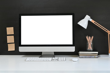 Workspace blank screen desktop computer, Mockup computer, lamp and home office accessories on white...