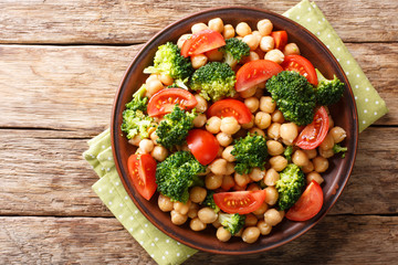 Delicious salad of broccoli, chickpeas and tomatoes closeup on a plate. horizontal top view