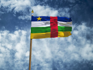 Central African Republic flag Silk waving flag of Central African Republic made transparent fabric with wooden flagpole gold spear on background blue sky white smoke clouds real photo 3d illustration