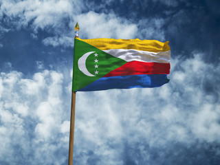 Comoros flag Silk waving flag of Comoros made transparent fabric with wooden flagpole gold spear on background sunny blue sky white smoke clouds real retro photo Countries of world 3d illustration