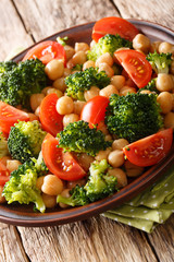 Delicious salad of broccoli, chickpeas and tomatoes closeup on a plate. vertical