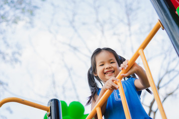 Asian little girl enjoys playing in a children playground