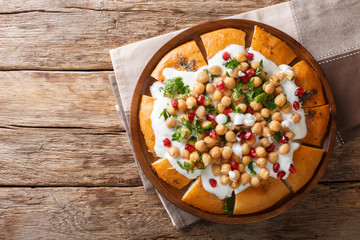 Middle Eastern pita with chickpeas, yogurt and pomegranate seeds close-up on a plate. Horizontal top view