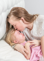 Mother touches the forehead of the child, checking the temperature